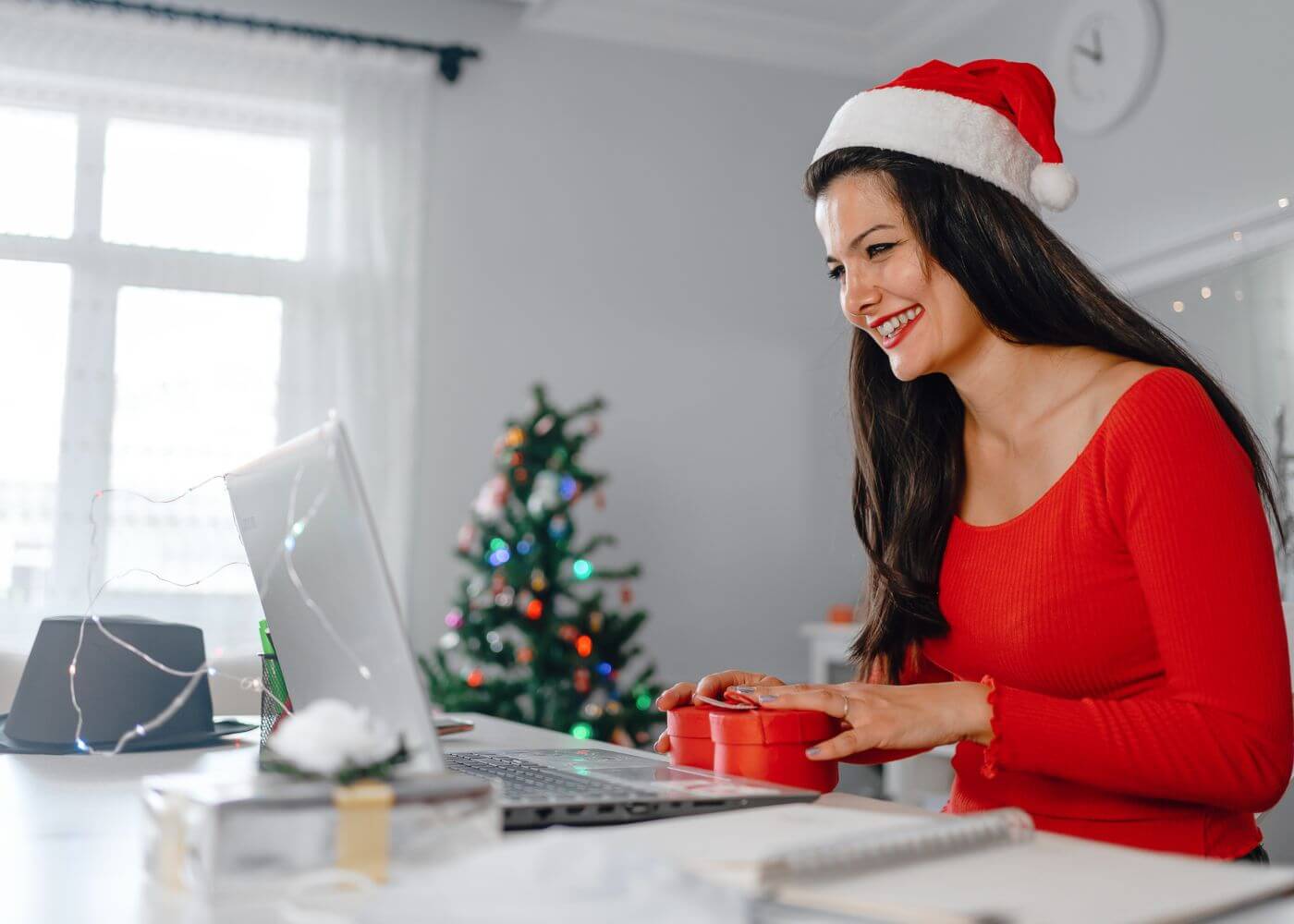 Brindes de fim de ano para empresas - Mulher digitando com chapéu do papai noel